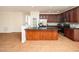 Spacious kitchen with granite countertops, stainless steel appliances, wood cabinetry, and an island open to the living space at 9412 Harvest Acres Ct, Raleigh, NC 27617