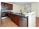 This kitchen features stainless steel appliances, granite countertops, and dark wood cabinetry with an island and skylight at 9412 Harvest Acres Ct, Raleigh, NC 27617