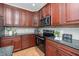 Kitchen features dark wood cabinets, granite countertops, stainless steel appliances, and tile backsplash at 9412 Harvest Acres Ct, Raleigh, NC 27617