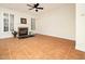 Living room with fireplace, window, plantation shutters, and tile floors offers bright and inviting space at 9412 Harvest Acres Ct, Raleigh, NC 27617