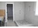 New bathroom with a tiled shower, pebble floor, niche, gray vanity, and a doorway to a walk-in closet at 1021 Smoke Willow Way # 130, Rolesville, NC 27571