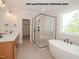Luxurious bathroom featuring a soaking tub, glass shower, double vanity, and tiled floors at 1021 Smoke Willow Way # 130, Rolesville, NC 27571