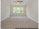 Bright bedroom features neutral walls, a ceiling fan, and three-panel windows showcasing the outdoor view at 1021 Smoke Willow Way # 130, Rolesville, NC 27571
