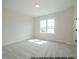 Spacious bedroom with carpeted floor and large window at 1021 Smoke Willow Way # 130, Rolesville, NC 27571