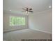 Bright bedroom with neutral walls, ceiling fan, and three-panel windows showcases the outdoor view at 1021 Smoke Willow Way # 130, Rolesville, NC 27571
