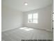 Inviting bedroom with a bright window offering ample natural light, complemented by neutral walls and carpet flooring at 1021 Smoke Willow Way # 130, Rolesville, NC 27571