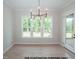 Well-lit dining area with large windows, contemporary chandelier, and hardwood floors creating a warm ambiance at 1021 Smoke Willow Way # 130, Rolesville, NC 27571