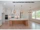 Open kitchen boasts a large island, white cabinetry, modern lighting, and stainless steel appliances at 1021 Smoke Willow Way # 130, Rolesville, NC 27571