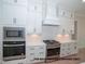Modern kitchen featuring sleek white cabinets and stainless steel appliances at 1021 Smoke Willow Way # 130, Rolesville, NC 27571