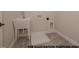 Functional laundry room featuring a utility sink, tiled flooring, and essential hookups for laundry appliances at 1021 Smoke Willow Way # 130, Rolesville, NC 27571
