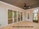 Covered patio boasts wood flooring, fan, and sliding glass doors, seamlessly connecting indoor and outdoor living spaces at 1021 Smoke Willow Way # 130, Rolesville, NC 27571