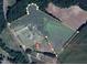 Aerial view highlighting property lines surrounding the home, nearby buildings, and expansive natural landscape at 1610 Woodards Dairy Rd, Middlesex, NC 27557