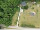 Aerial view of the property showing a long driveway, a house with a metal roof, and plenty of green space at 1610 Woodards Dairy Rd, Middlesex, NC 27557