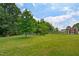 Green backyard with mature trees, large shed and chicken coops at 1610 Woodards Dairy Rd, Middlesex, NC 27557