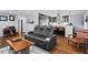 Spacious living room featuring hardwood floors, a modern leather sofa, and view into the kitchen at 1801 Liberty St, Durham, NC 27703