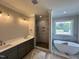 Bright bathroom with double vanity, walk-in shower, and a modern freestanding tub at 190 Broadleaf Ln, Louisburg, NC 27549