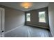 Well-lit bedroom with dual windows, neutral paint, and new carpeting covered with protective wrap at 190 Broadleaf Ln, Louisburg, NC 27549