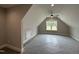 Spacious bonus room with vaulted ceilings, fan, and large window offering ample natural light at 190 Broadleaf Ln, Louisburg, NC 27549