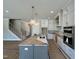 Open-concept kitchen featuring white cabinets, stainless steel appliances, and a large island at 190 Broadleaf Ln, Louisburg, NC 27549