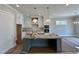 Spacious kitchen with white cabinets, stainless steel appliances, a gray island, and pendant lighting at 190 Broadleaf Ln, Louisburg, NC 27549