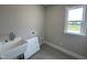 Functional laundry room featuring utility sink and a window offering natural light with views to the exterior at 190 Broadleaf Ln, Louisburg, NC 27549