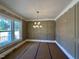 Sunlit living room with decorative trim, large window, and contemporary chandelier at 190 Broadleaf Ln, Louisburg, NC 27549
