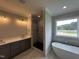 Bathroom with double vanity, walk-in shower, and modern soaking tub at 190 Broadleaf Ln, Louisburg, NC 27549