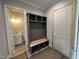 Well-organized mud room with storage bench and view into a bright, newly renovated bathroom at 190 Broadleaf Ln, Louisburg, NC 27549
