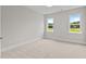 Bright bedroom with two windows offering scenic outdoor views and plush carpeting at 190 Broadleaf Ln, Youngsville, NC 27596