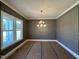 Formal dining room featuring custom wall paneling, large window, and elegant chandelier at 190 Broadleaf Ln, Youngsville, NC 27596