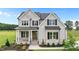 Charming two-story home featuring a covered porch, stone accents, and professional landscaping at 190 Broadleaf Ln, Youngsville, NC 27596