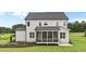 Rear view of this two-story home featuring a screened in porch and lush landscaping at 190 Broadleaf Ln, Youngsville, NC 27596