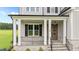 Inviting front porch with stone accents, wood door, and elegant railing at 190 Broadleaf Ln, Youngsville, NC 27596