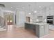 Modern open-concept kitchen with gray island, white cabinets, and stainless steel appliances at 190 Broadleaf Ln, Youngsville, NC 27596