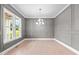 Sophisticated living room with paneled walls, hardwood floors, and a modern chandelier at 190 Broadleaf Ln, Youngsville, NC 27596