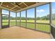 Spacious screened porch with wood flooring, ceiling fan, and a beautiful view of the expansive lawn at 190 Broadleaf Ln, Youngsville, NC 27596