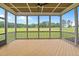 Light-filled screened-in porch featuring wood floors and views of the expansive green lawn at 190 Broadleaf Ln, Youngsville, NC 27596