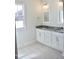 Well-lit bathroom with dual vanities, granite counters, and tile flooring at 24 Surles Landing Way, Benson, NC 27504