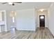 Open living area with modern ceiling fan and wood-look flooring, leading to the front door and other rooms at 24 Surles Landing Way, Benson, NC 27504
