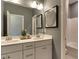 Bathroom with double vanity, white cabinets, and a large mirror at 2940 Hanging Valley Way, Wake Forest, NC 27587