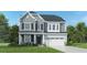 Two-story home with gray siding, stone accents, and a two-car garage at 2940 Hanging Valley Way, Wake Forest, NC 27587