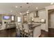 Open kitchen with island seating, stainless steel appliances, and dark hardwood floors at 2940 Hanging Valley Way, Wake Forest, NC 27587