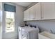 Laundry room with white cabinets, a utility sink, and washer/dryer at 2940 Hanging Valley Way, Wake Forest, NC 27587