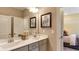 Double vanity bathroom with gray cabinets and decorative wall art at 2948 Hanging Valley Way, Wake Forest, NC 27587