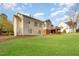 Large backyard with green grass and the home's beige siding, showcasing the outdoor space and potential for landscaping at 306 Neuse Ridge Dr, Clayton, NC 27527