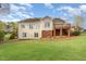 Spacious backyard view featuring a deck, beige siding, and well-manicured lawn perfect for outdoor activities at 306 Neuse Ridge Dr, Clayton, NC 27527