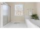 Bright bathroom featuring a bathtub and separate shower with a window letting in natural light at 306 Neuse Ridge Dr, Clayton, NC 27527