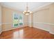 Bright dining room featuring hardwood floors, a classic chandelier, and ample natural light, creating an inviting atmosphere at 306 Neuse Ridge Dr, Clayton, NC 27527