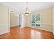 Elegant dining room with hardwood floors, a stylish chandelier, and natural light from a large window at 306 Neuse Ridge Dr, Clayton, NC 27527
