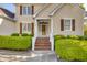 Charming front exterior with brick stairs, white railings, and manicured bushes at 306 Neuse Ridge Dr, Clayton, NC 27527